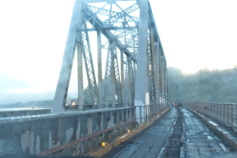 20101204_074121 D3.jpg - Crossing the Rio Chagras on wooden bridge.  Rain on window and mist makes for eery view